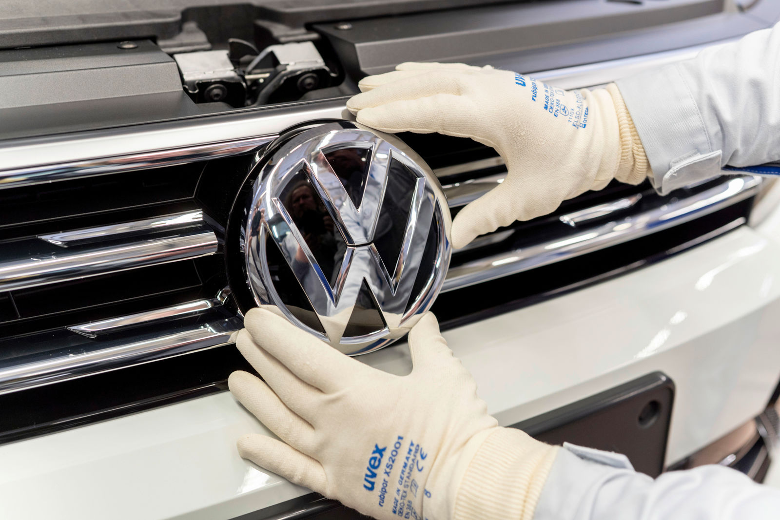 Montage Werk Wolfsburg: Anbringen des VW-Logos im Kühlergrill
